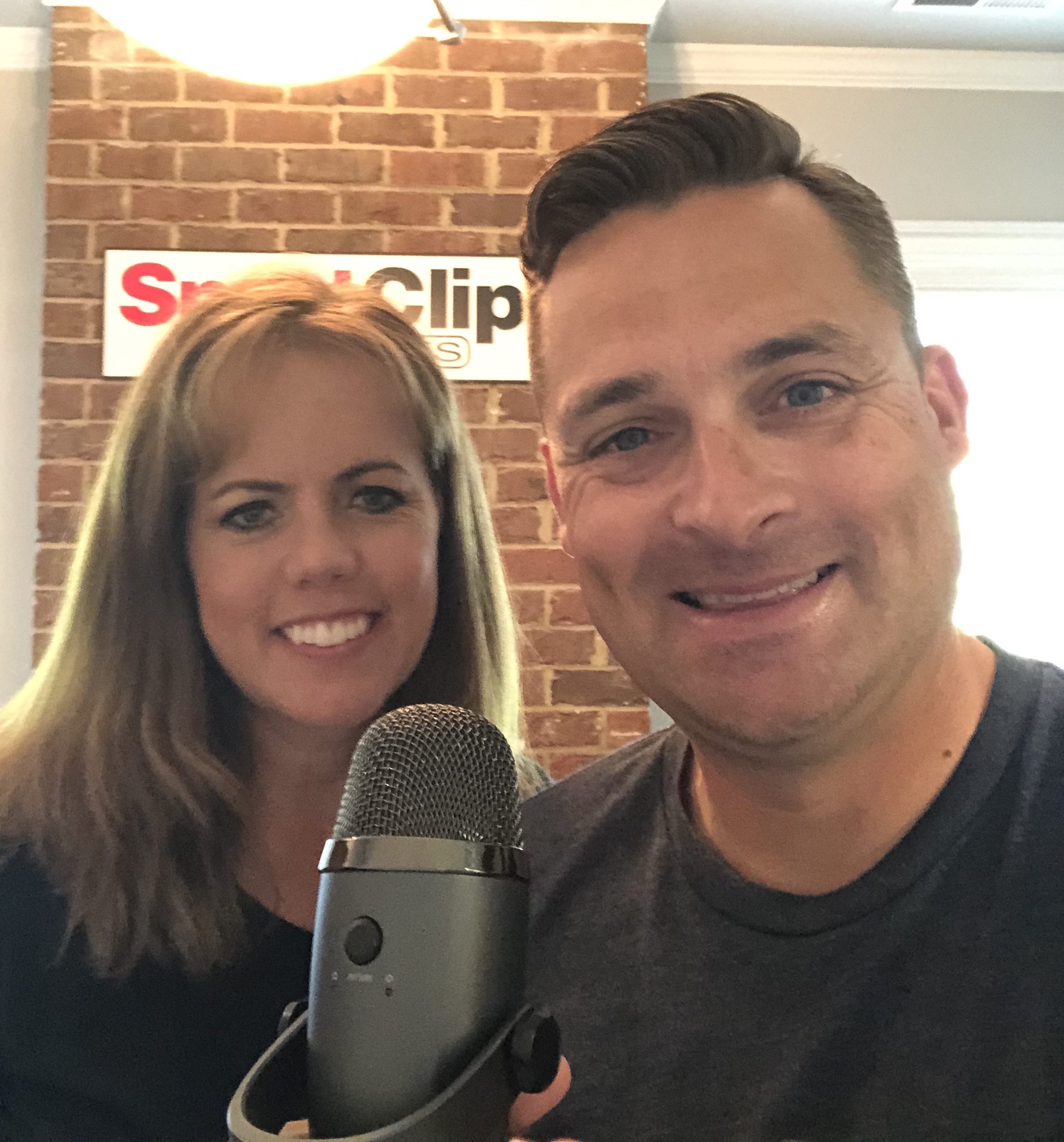 Chad Jordan and Debra Sawyer holding a microphone